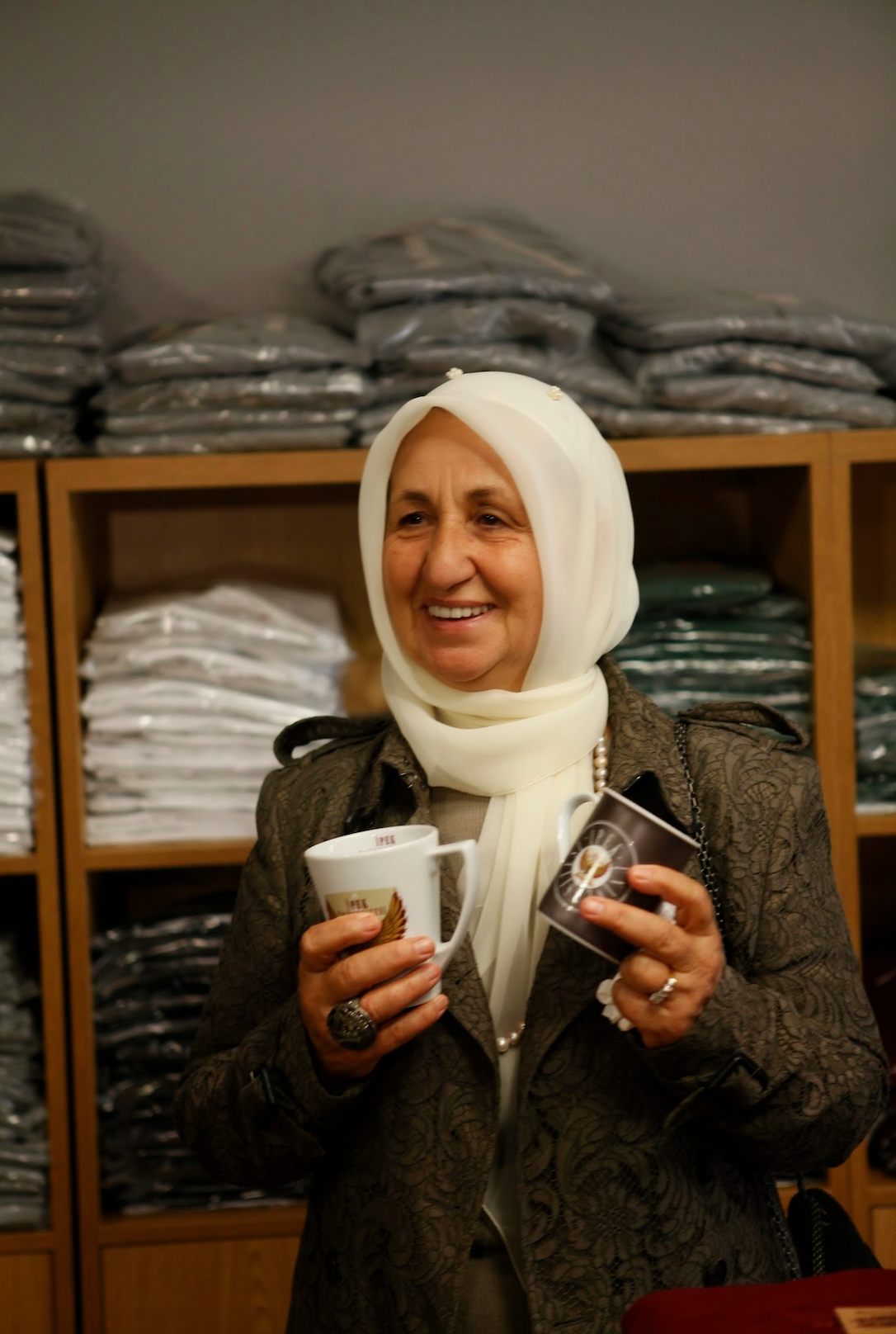 Melek İpek, holding a mug marked İpek University.